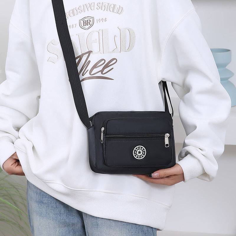 Crossbody torba od Oxford platna, kompaktna kvadratna forma, sa zatvaračem i pretincima za telefon i dokumente
