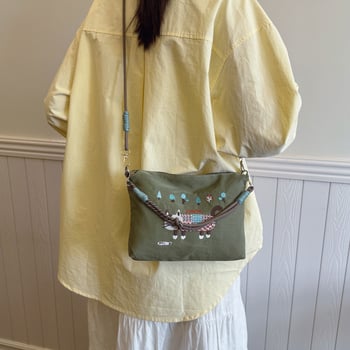 Krosbody torba preko jednog ramena – velik kapacitet, vodootporan materijal, izvezen motiv mačice, zatvarač, podstava od poliestera