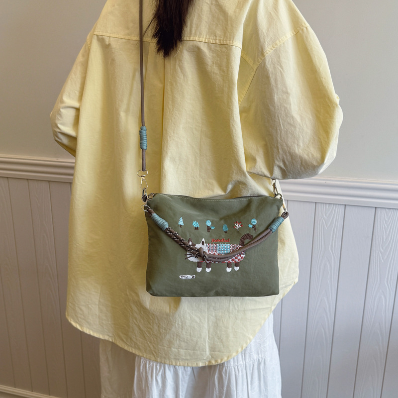 Krosbody torba preko jednog ramena – velik kapacitet, vodootporan materijal, izvezen motiv mačice, zatvarač, podstava od poliestera