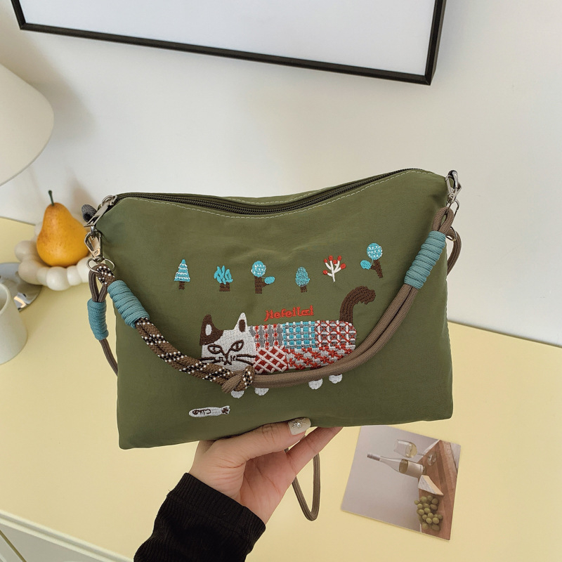 Krosbody torba preko jednog ramena – velik kapacitet, vodootporan materijal, izvezen motiv mačice, zatvarač, podstava od poliestera