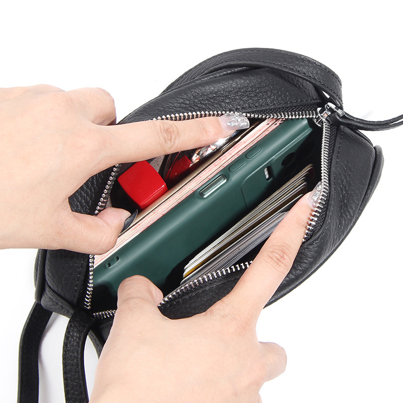 Crossbody torba od prve sloje goveđe kože, ovalni oblik, zatvaranje na zip, unutarnje džepove za telefon i ID