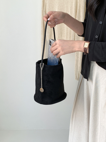 Suede bucket bag cilindričnog oblika s magnetskim zatvaračem; unutarnja džep s džepom na zatvarač, džep za mobitel i džep za ID.