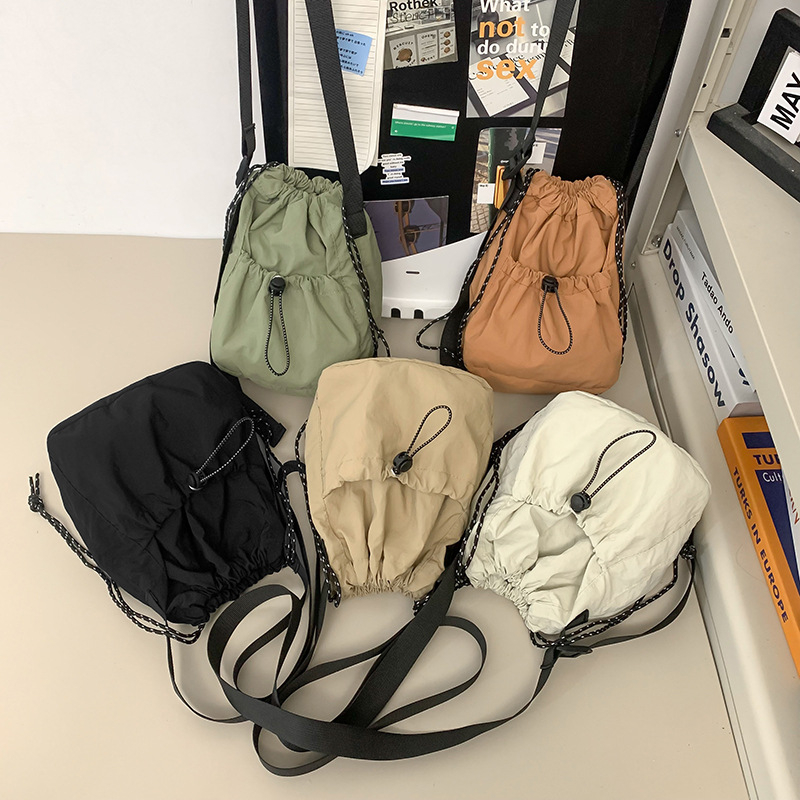 Crossbody bucket torba – Oxford platno, zatvarač, vodoravni kvadratni oblik, poliester podstava, jednostruka naramenica, gradski stil.