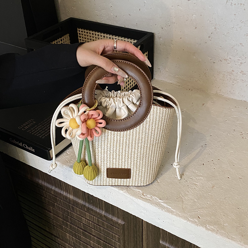 PU materijal crossbody torbica u bucket bag stilu, gradski minimalistički dizajn, pravokutnog oblika, zatvaranje šnira, unutarnji džepovi