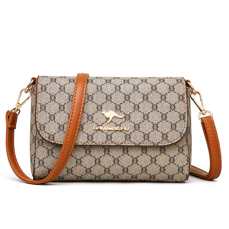 Ženska crossbody torba kvadratnog oblika, PVC materijal, podstava poliester, zatvaranje kapicom, unutarnji džepovi: zip pretinac, džep za mobitel, svakodnevna upotreba, jesen 2023