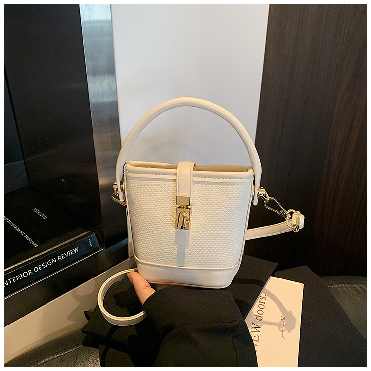 PU anyagú kancsó alakú válltáska, városi minimalist stílus, záródó csattal, poliészter bélés, egypántos vállpánt, belső cipzáras zseb és telefonzseb.