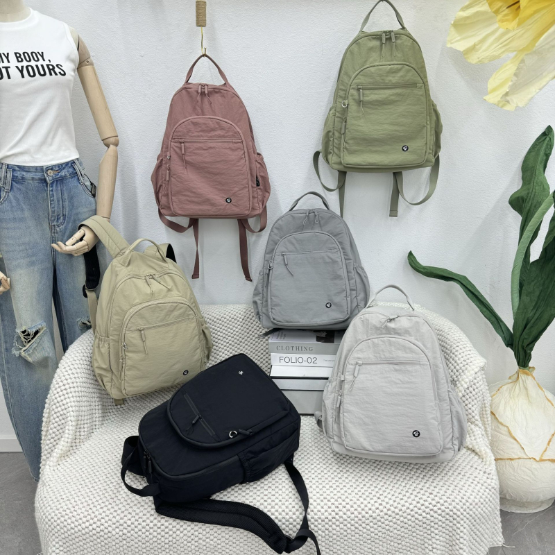 Rucsac feminin din nylon, ușor și versatil; include buzunar laminat cu fermoar, deschidere cu șnur, buzunar exterior deschis, spațiu intern