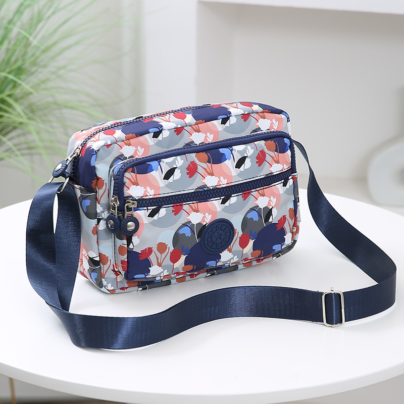 Crossbody torba od Oxford materijala, urban minimalistički stil, horizontalni kvadratnog oblika, više pretinaca, poliester podstava, zatvarač