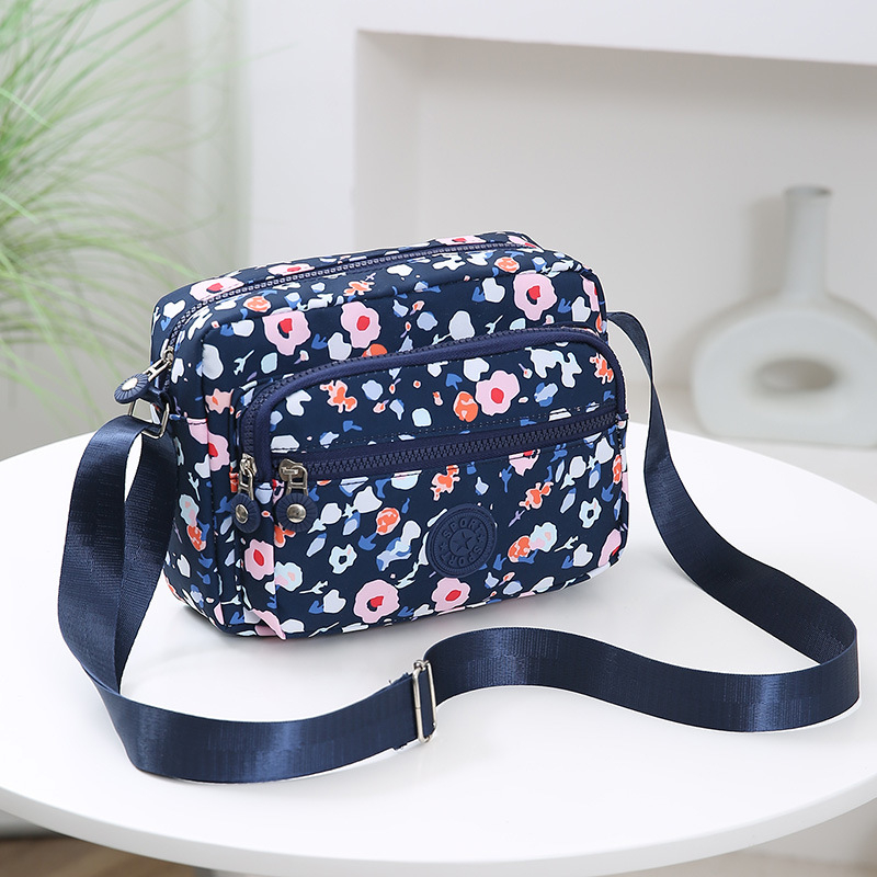 Crossbody torba od Oxford materijala, urban minimalistički stil, horizontalni kvadratnog oblika, više pretinaca, poliester podstava, zatvarač