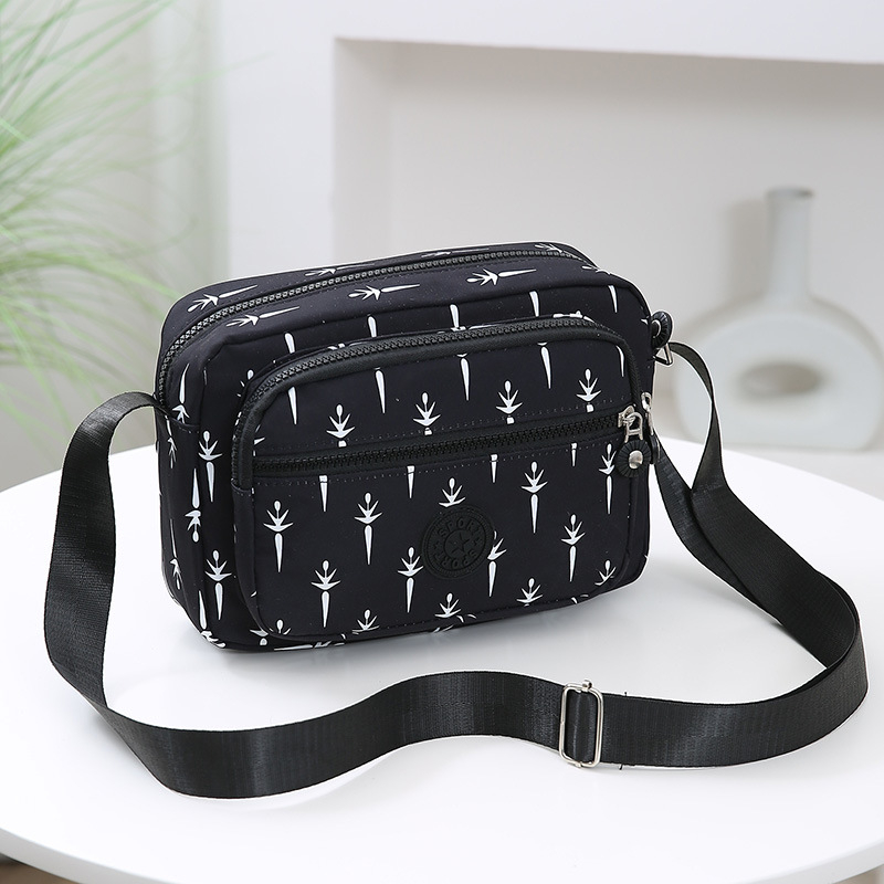 Crossbody torba od Oxford materijala, urban minimalistički stil, horizontalni kvadratnog oblika, više pretinaca, poliester podstava, zatvarač