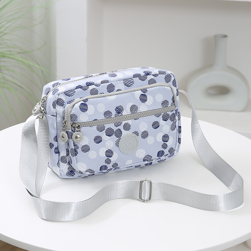 Crossbody torba od Oxford materijala, urban minimalistički stil, horizontalni kvadratnog oblika, više pretinaca, poliester podstava, zatvarač