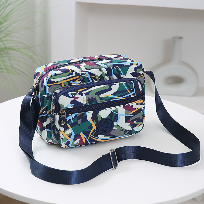 Crossbody torba od Oxford materijala, urban minimalistički stil, horizontalni kvadratnog oblika, više pretinaca, poliester podstava, zatvarač