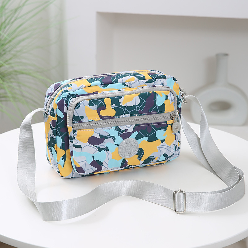 Crossbody torba od Oxford materijala, urban minimalistički stil, horizontalni kvadratnog oblika, više pretinaca, poliester podstava, zatvarač