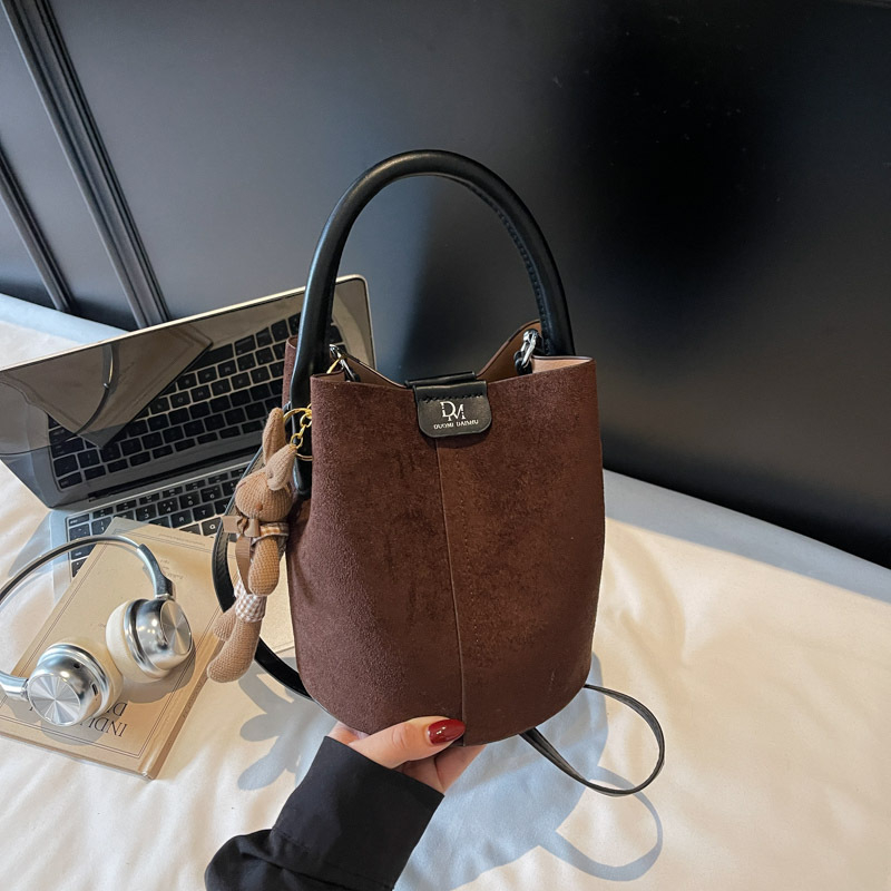 Velúrová bucket taška, mestský minimalistický štýl, magnetické zapínanie, jednoramenný popruh, vnútorné vrecká na telefón a dokumenty, podšívka z umelej kože