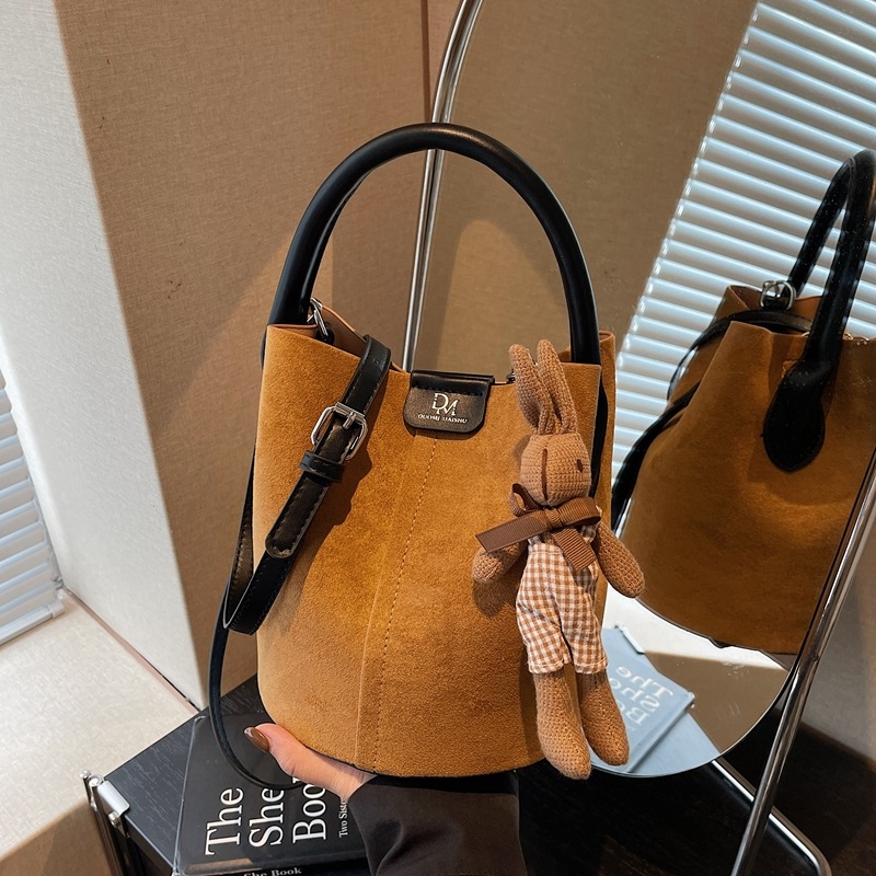 Velúrová bucket taška, mestský minimalistický štýl, magnetické zapínanie, jednoramenný popruh, vnútorné vrecká na telefón a dokumenty, podšívka z umelej kože