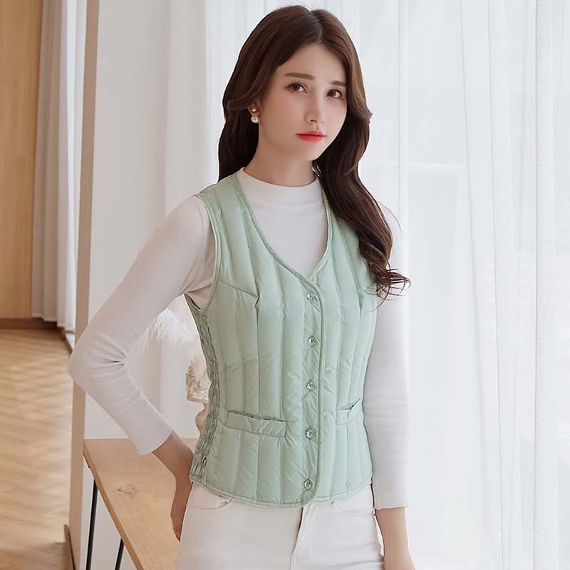 Γυναικείο κοντό γιλέκο με πούπουλα, λεπτό και εφαρμοστό, χωρίς μανίκια χωρίς γιακά; γέμισμα: πούπουλο από λευκή πάπια; εξωτερικό ύφασμα: 100% πολυεστέρας; επένδυση: πολυεστέρας; μήκος: 40–50 cm