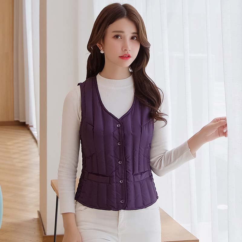 Γυναικείο κοντό γιλέκο με πούπουλα, λεπτό και εφαρμοστό, χωρίς μανίκια χωρίς γιακά; γέμισμα: πούπουλο από λευκή πάπια; εξωτερικό ύφασμα: 100% πολυεστέρας; επένδυση: πολυεστέρας; μήκος: 40–50 cm