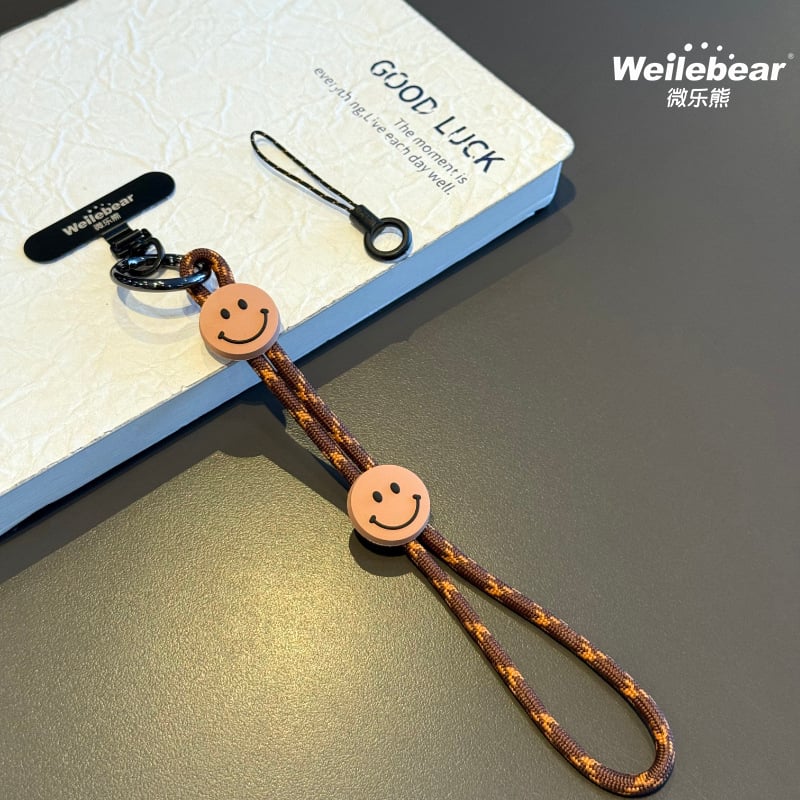 Koniec šmýkaniu! Šnúrka na telefón s usmievavou tváričkou, nastaviteľný remienok na zápästie, unisex prívesok na fotoaparát, šnúrka proti strate na vonkajšie použitie.