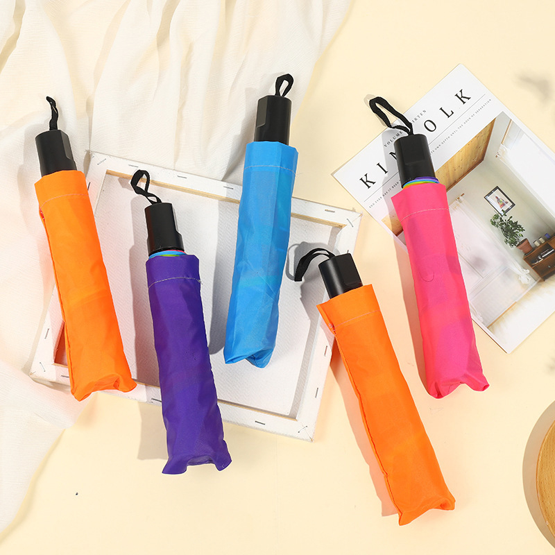 Önazonos logóval és szivárványos mintázattal rendelkező összecsukható esernyő