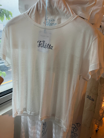 Bijeli pamukasti T shirt s okruglim izrezom, slobodnog kroja, kratkih rukava, natpisom slovima – Ljeto 2025