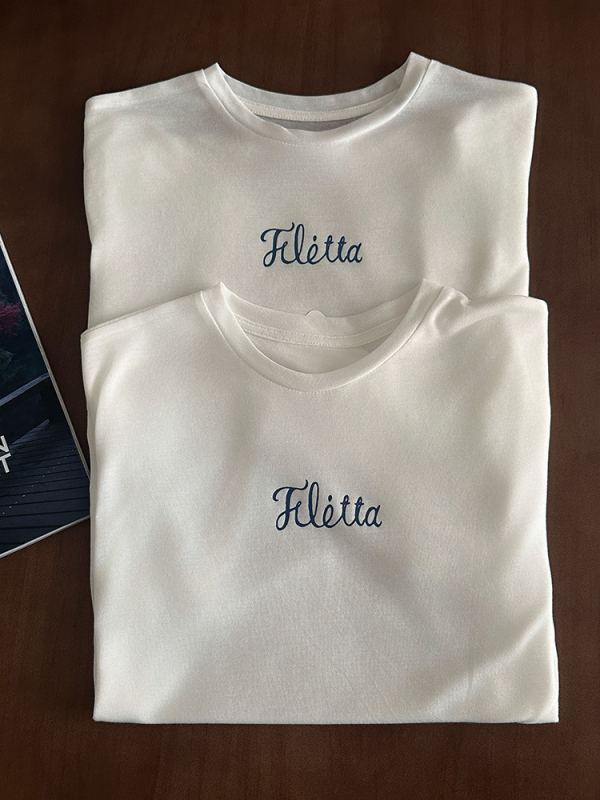 Bijeli pamukasti T shirt s okruglim izrezom, slobodnog kroja, kratkih rukava, natpisom slovima – Ljeto 2025