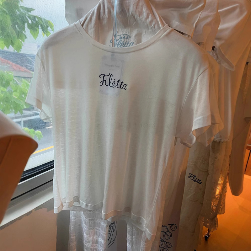 Bijeli pamukasti T shirt s okruglim izrezom, slobodnog kroja, kratkih rukava, natpisom slovima – Ljeto 2025