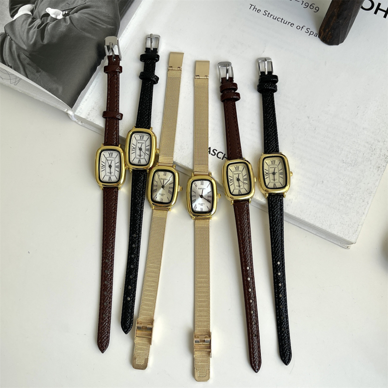 Ženski sat s vintage inspiracijom, zlatnog tona, kvarcni mehanizam, cifernik s rimskim brojevima, tanak remen, casual minimalistički stil.
