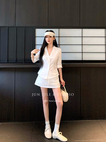 Двоен комплект: бяла риза с V-образно деколте и тясна талия, дълги ръкави, къса пола с висока талия.