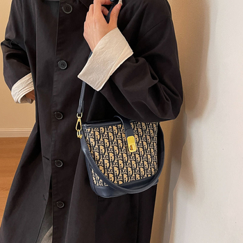 Ženska torba tipa kanta s natpisom, vintage izgled, zaključavanje bravom, za rame ili crossbody.
