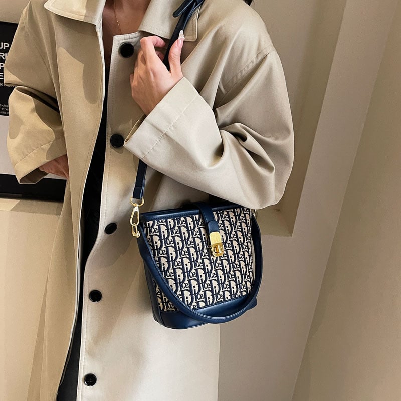 Ženska torba tipa kanta s natpisom, vintage izgled, zaključavanje bravom, za rame ili crossbody.