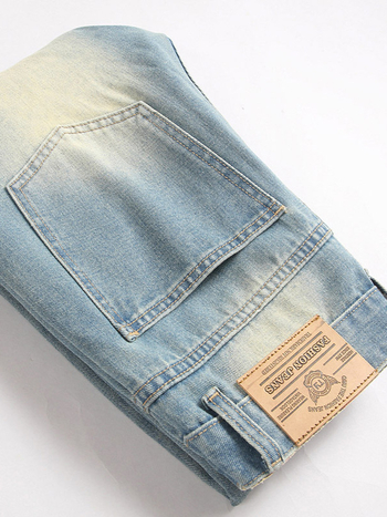 Muške traperice s laganim izblijedjelim efektom i poderotinama, elastična ravna nogavica, opuštena silueta, retro casual stil.