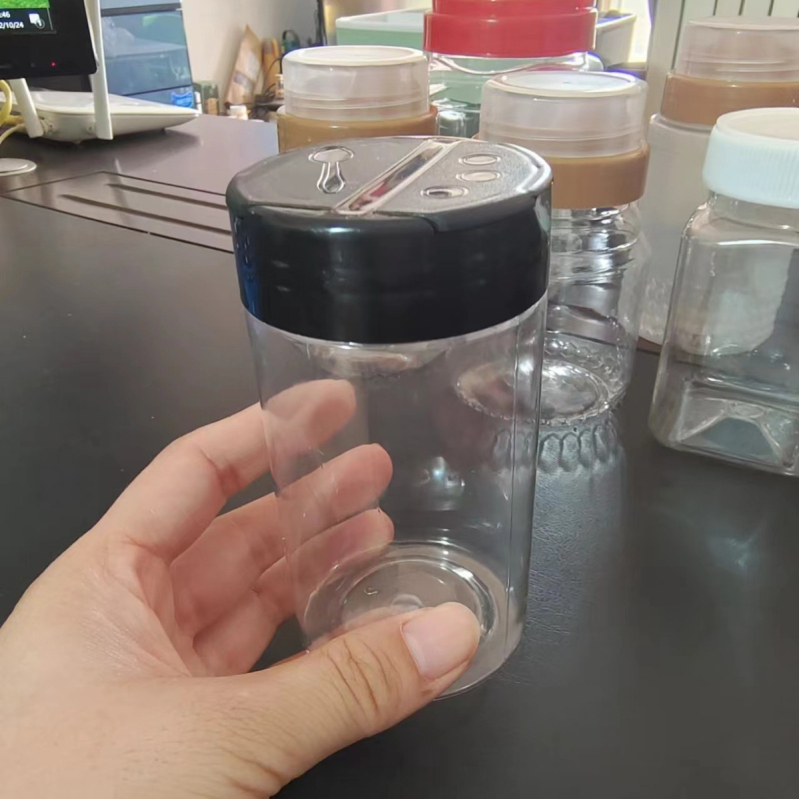 Prozirna PET plastična boca s crnom kapom i širokim otvorom za kuhinjske začine