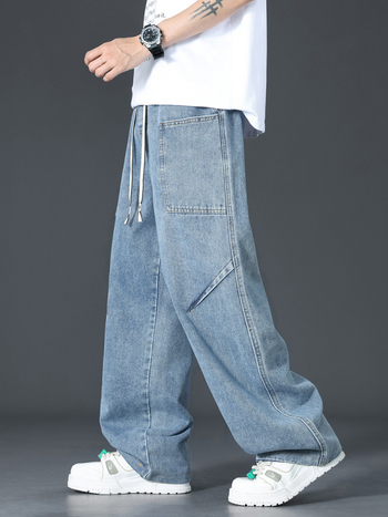 Muške traperice u američkom retro stilu s dekonstruiranim krojem, pojas s vezicom i elastikim, mekani isprani denim, više džepova, lagano šire nogavice za ljeto.