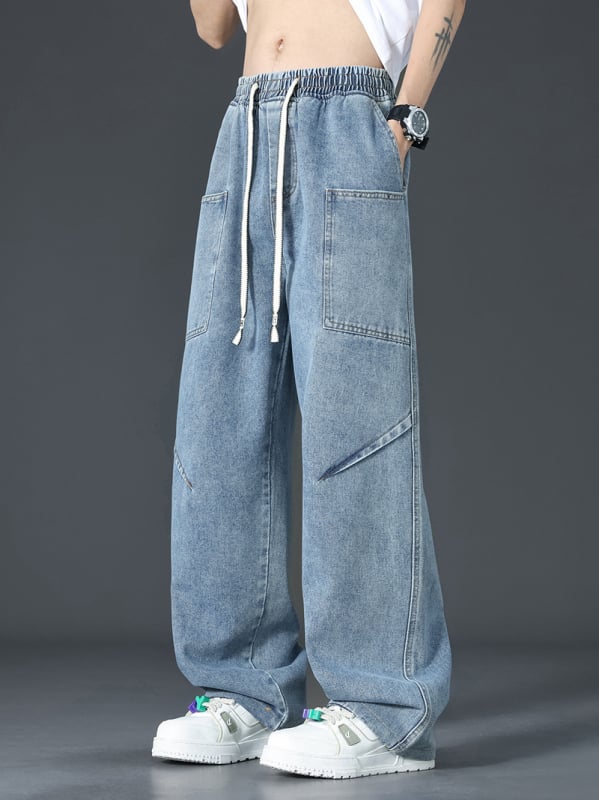 Muške traperice u američkom retro stilu s dekonstruiranim krojem, pojas s vezicom i elastikim, mekani isprani denim, više džepova, lagano šire nogavice za ljeto.