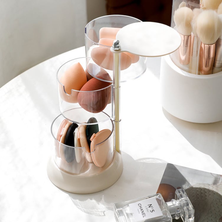 Rotirajuća prozirna kozmetička kutija s odjeljcima za puderne puffice, spužvice za šminkanje i vatu.