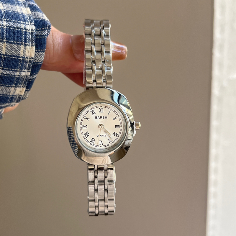 Ženski sat u vintage stilu, s malim zlatnim kućištem, elegantan minimalistički dizajn, metalni remen s rimskim lancem.