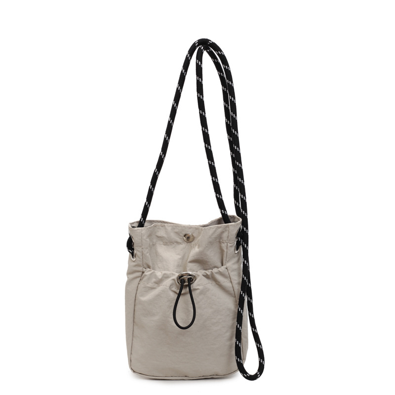 Platnena bucket torbica, mala veličina, s jednim remenom za crossbody, minimalističkog dizajna, jednobojna, pretinac za telefon, svakodnevna upotreba