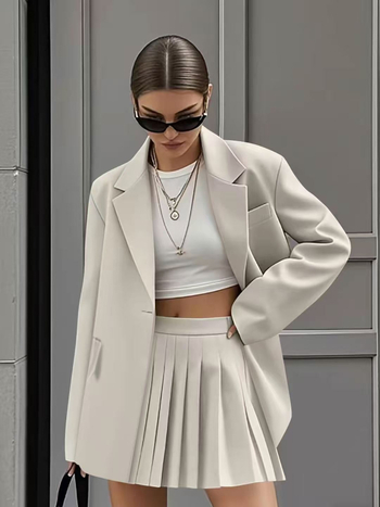Ženski kostim s plisiranom suknjom – casual moda (proljeće 2025)