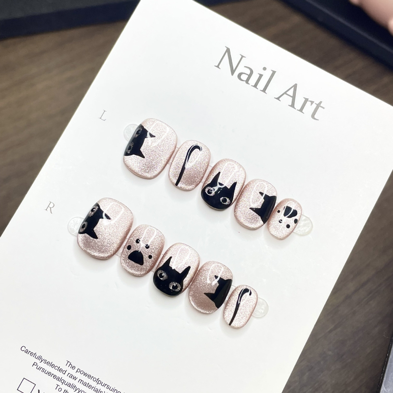 Kézzel festett Cat-Eye hatású press-on műkörmök fekete és rózsaszín csillámos részletekkel – trendi, édes és minimalistikus körömdesign