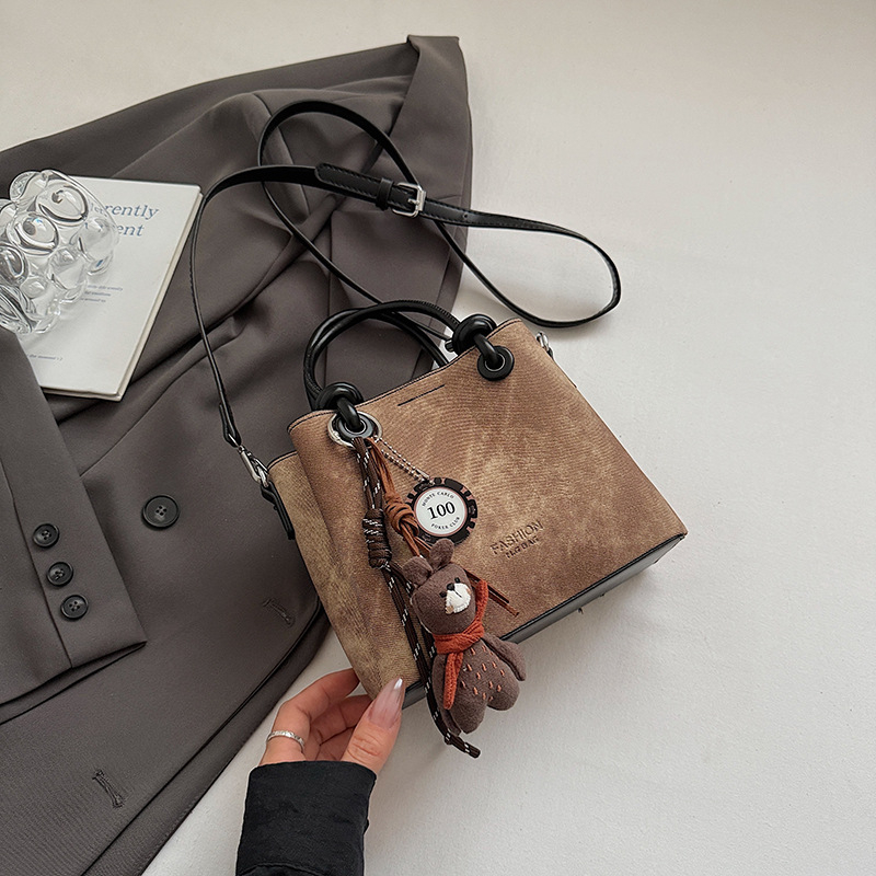 Mala crossbody torba tipa bucket sa zatvaračem, gradski minimalistički dizajn, retro inspiracija