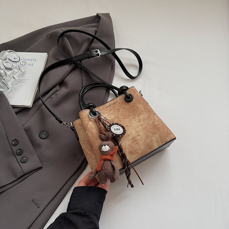 Mala crossbody torba tipa bucket sa zatvaračem, gradski minimalistički dizajn, retro inspiracija