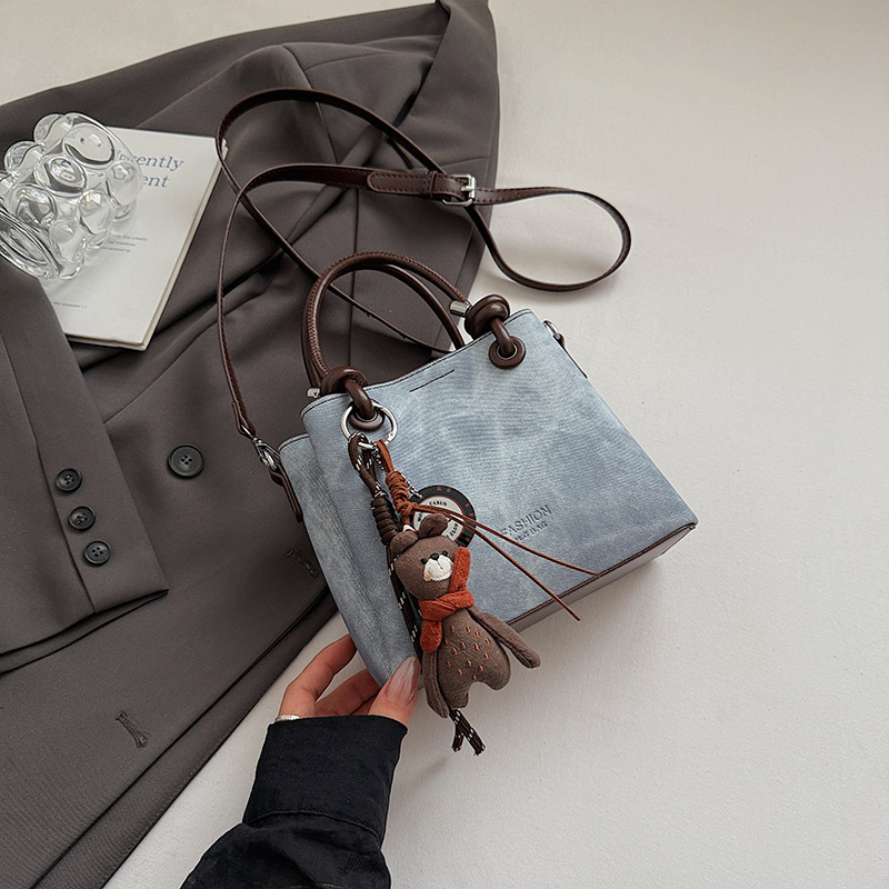 Mala crossbody torba tipa bucket sa zatvaračem, gradski minimalistički dizajn, retro inspiracija