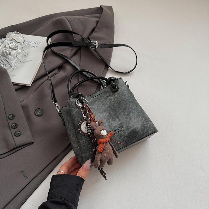 Mala crossbody torba tipa bucket sa zatvaračem, gradski minimalistički dizajn, retro inspiracija