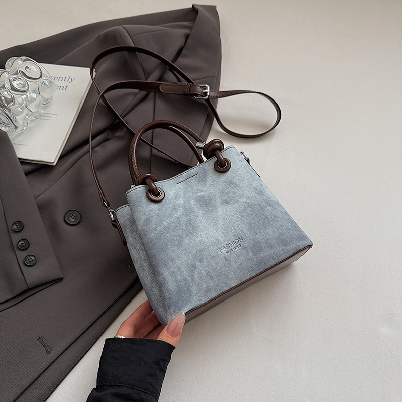 Mala crossbody torba tipa bucket sa zatvaračem, gradski minimalistički dizajn, retro inspiracija