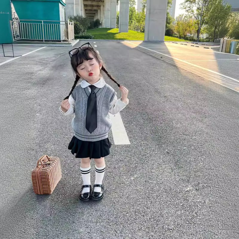 Lányok japán stílusú iskolai egyenruha szoknyával és kötött hosszú ujjú mellényes szettel