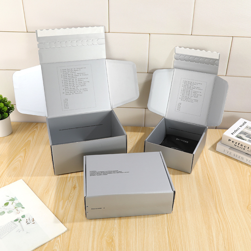 Cutie cadou cu fermoar argintiu-gri pentru haine și lenjerie, ambalaj rigid din carton ondulat, dimensiuni 200x130x65 mm, 250x200x120 mm, 240x200x80 mm, 180x195x80 mm.