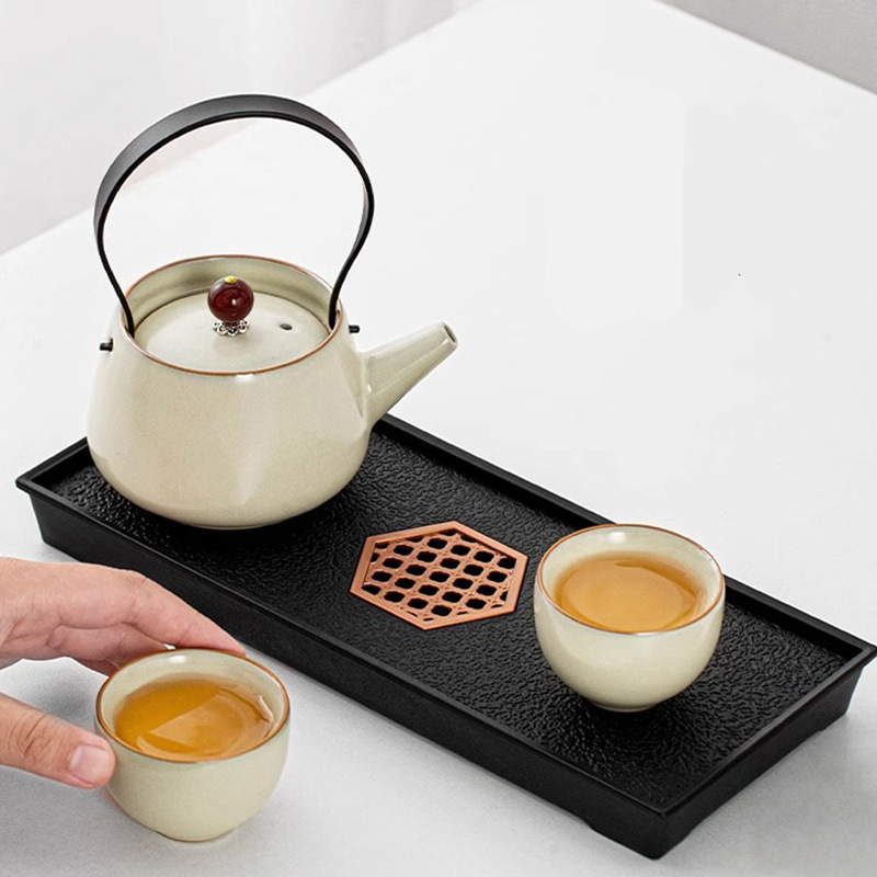 Set Gongfu de ceai bej pentru doi — ceainic din porțelan cu mâner, două cești și tavă de ceai.