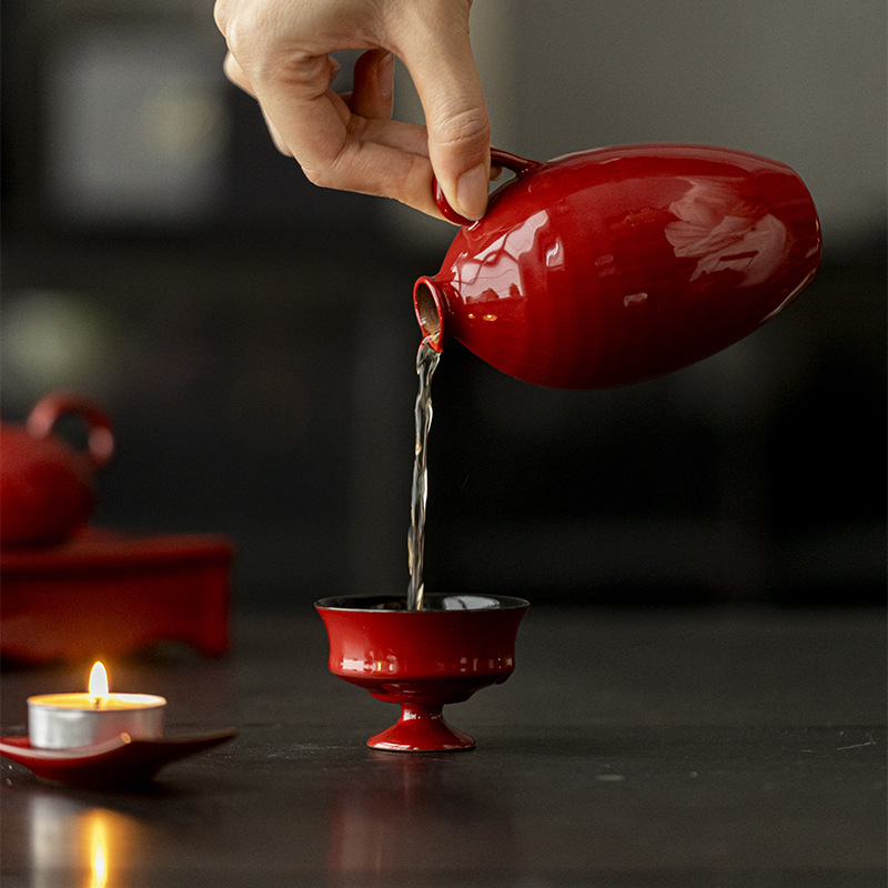 Dispenser ceramic pentru vin într-o nuanță oker-roșu și vas de încălzire, aranjament floral în stil chinezesc, cu o vază mică