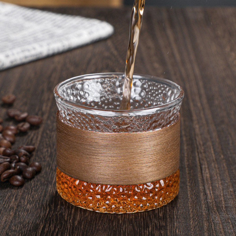 Ceașcă de cafea din sticlă cu inel din lemn izolant, textură ciocănită și vene verticale