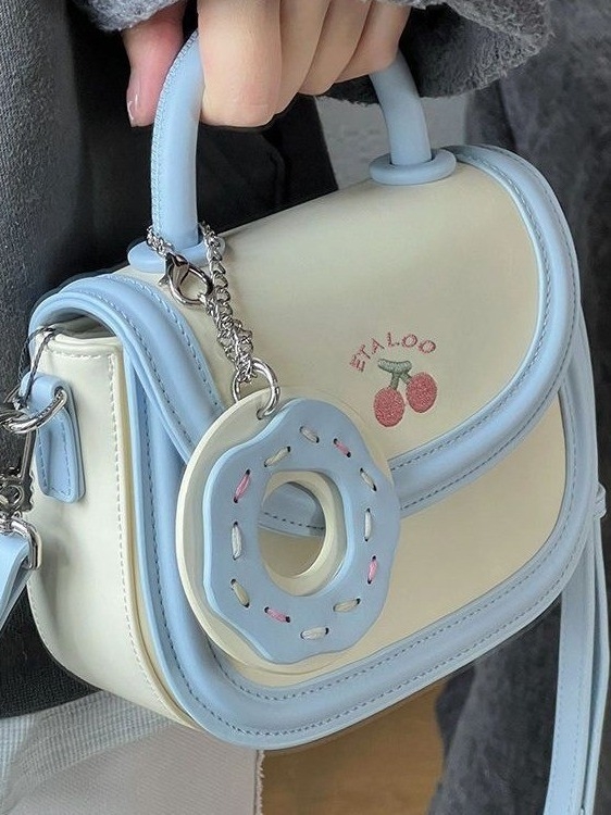 Mala sedlasta torbica biscuit off-white boje, japanskog stila, s ručkom, remenom i crossbody nošenjem, za žene, proljeće–ljeto.